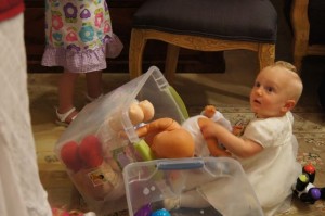 Little girl playing with a box of toys from home